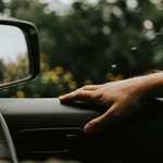 Driver hand on a car steering wheel
