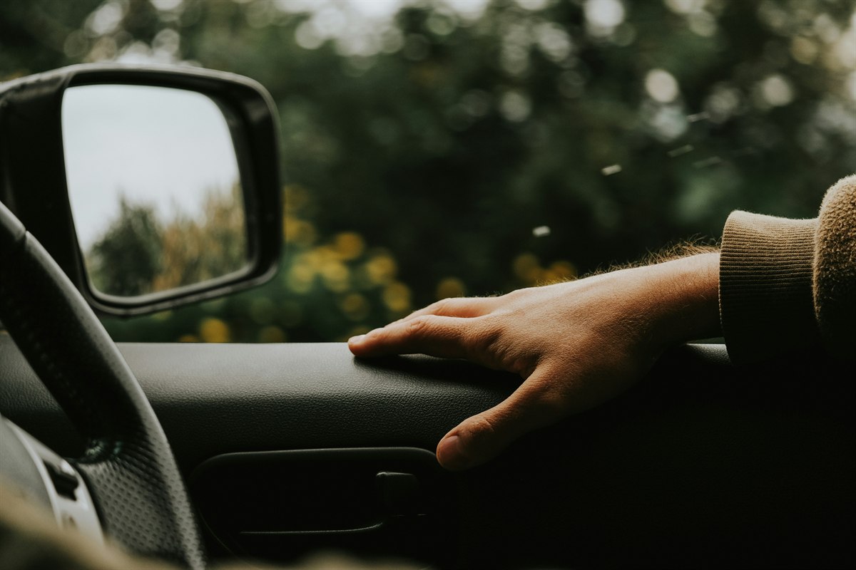 Driver hand on a car steering wheel
