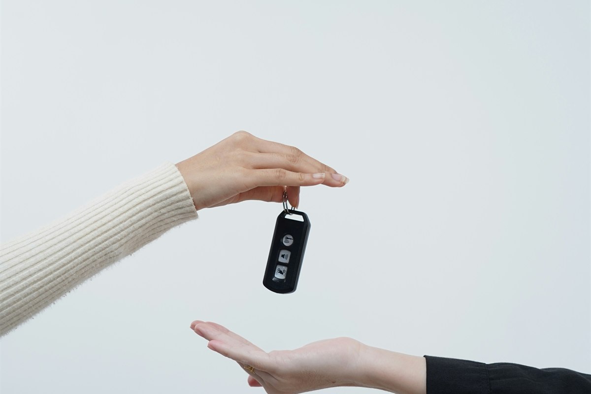 Hands exchanging a vehicle key